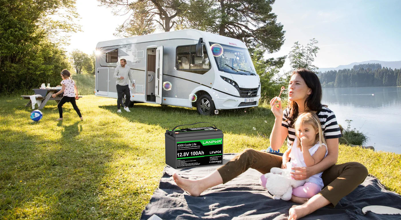 Family by a camper van with a Leisureland battery pack in the foreground.